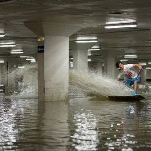 英国地下停车场发大水 男子踏滑板穿梭滑水